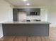 A modern kitchen features gray cabinets, a granite island, and stainless steel microwave at 167 Lotus Ave, Smithfield, NC 27577