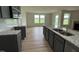 An open kitchen features gray cabinets, stainless appliances, and a granite island overlooking the living area at 167 Lotus Ave, Smithfield, NC 27577