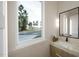 Well-lit bathroom featuring a large window, modern vanity, and stylish mirror at 1800 Pershing Rd, Raleigh, NC 27608