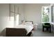 Cozy bedroom with a twin bed, natural light, and a comfortable chair at 1800 Pershing Rd, Raleigh, NC 27608