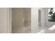 Tiled shower area with glass door, modern fixtures, and white tile flooring, open to the bathroom at 1800 Pershing Rd, Raleigh, NC 27608