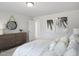 Comfortable bedroom featuring neutral decor, natural light, and a stylish dresser with a round mirror at 1931 Ballard Rd, Fuquay Varina, NC 27526