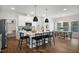 Bright, open kitchen features white cabinets, stainless steel appliances, a large island with seating, and wood floors at 1931 Ballard Rd, Fuquay Varina, NC 27526
