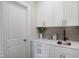 A stylish kitchenette with white cabinets, quartz countertops, mosaic backsplash, and black matte faucet at 1931 Ballard Rd, Fuquay Varina, NC 27526