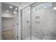Elegant shower with sleek glass enclosure, marble-look tile, and convenient built-in shelving at 1931 Ballard Rd, Fuquay Varina, NC 27526