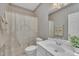 Bathroom with striped wallpaper, a white sink, and shower with floral curtains at 1933 Castle Pines Dr, Raleigh, NC 27604