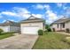 Exterior shot showcasing the attached garage with a wide driveway and landscaped surroundings at 1933 Castle Pines Dr, Raleigh, NC 27604