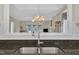 Bright kitchen featuring granite counters, a stainless steel sink, and a view into the living room at 1933 Castle Pines Dr, Raleigh, NC 27604