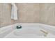 Bathroom featuring a soaking tub with gold-tone hardware and patterned wallpaper at 1933 Castle Pines Dr, Raleigh, NC 27604