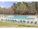 Community pool featuring plenty of lounge chairs, with shade trees around the perimeter at 1933 Castle Pines Dr, Raleigh, NC 27604