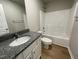 Well-lit bathroom with a granite countertop, shower and bath combo, and ample space for comfort at 199 Lotus Ave, Smithfield, NC 27577