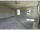 Open-concept living room with neutral walls, carpet, large windows, and seamless flow to the entryway at 199 Lotus Ave, Smithfield, NC 27577