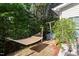 Secluded backyard with a hammock, mature trees, and well-manicured landscaping at 208 Station Dr, Morrisville, NC 27560
