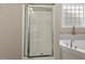 Bathroom with a garden tub and a glass door shower next to a small window at 208 Station Dr, Morrisville, NC 27560