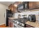 Modern kitchen with stainless steel appliances, granite countertops, and dark wood cabinetry at 208 Station Dr, Morrisville, NC 27560