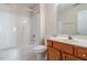 Bathroom with a white tub/shower combo, toilet, wooden vanity, sink and mirror at 2089 White Pond Ct, Apex, NC 27523
