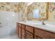 Full bathroom featuring double sinks, wood cabinets, decorative wallpaper, and a shower-tub combo at 2089 White Pond Ct, Apex, NC 27523