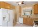 Kitchen featuring wooden cabinets, white appliances, granite countertops, and tile flooring at 2089 White Pond Ct, Apex, NC 27523