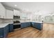 Well-equipped kitchen featuring stainless steel appliances, light countertops, and contrasting blue and white cabinetry at 2407 Miriam Cir, Durham, NC 27704