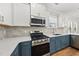 Close-up showcasing the stainless steel gas range, and stylish white and blue cabinets in the kitchen at 2407 Miriam Cir, Durham, NC 27704