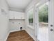 Well-lit laundry room featuring wood-look floors, washer/dryer hookups and access to a patio through a glass door at 2407 Miriam Cir, Durham, NC 27704