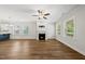 Bright living room featuring hardwood floors, a ceiling fan, and a charming fireplace at 2407 Miriam Cir, Durham, NC 27704