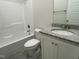 Bathroom featuring shower-tub combo, granite-look vanity, and gray tile floors at 253 Busterfield Ct, Benson, NC 27504