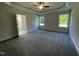 Spacious main bedroom featuring plush gray carpet, tray ceilings, and two bright windows at 253 Busterfield Ct, Benson, NC 27504