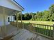 A charming wooden porch with railings offers views of the expansive yard and surrounding trees at 253 Busterfield Ct, Benson, NC 27504