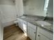 Bright bathroom featuring a double sink vanity with granite countertop and tub-shower combo at 253 Lotus Ave, Smithfield, NC 27577