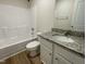 Well-lit bathroom with a granite vanity, shower-tub combination, and wood-look flooring at 253 Lotus Ave, Smithfield, NC 27577