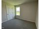 Neutral bedroom with carpet flooring, window, and a door to maximize the space at 253 Lotus Ave, Smithfield, NC 27577