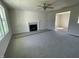 Spacious living room featuring a fireplace, plush carpeting and a bright, sunlit window at 253 Lotus Ave, Smithfield, NC 27577