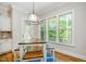Sunlit breakfast nook features a wood table set, blue rug, and window views to the outdoor greenery at 304 Villa Dr, Durham, NC 27712