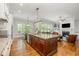 Open-concept kitchen with granite island, hardwood floors, and views to the living area with a fireplace at 304 Villa Dr, Durham, NC 27712