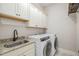Well-equipped laundry room with front-load washer and dryer, sink, and ample cabinet space at 304 Villa Dr, Durham, NC 27712