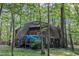 View of geodesic dome home with covered porch, surrounded by lush trees in a wooded area at 3312 Hawk Ridge Rd, Chapel Hill, NC 27516