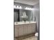 Bathroom with a double sink vanity, large mirror, and a white orchid centerpiece at 3609 Cold Harbour Dr, Raleigh, NC 27610