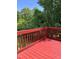 Open red deck surrounded by a lush green backdrop of mature trees, creating a private retreat at 3609 Cold Harbour Dr, Raleigh, NC 27610