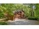Two-story house with garage and cozy porch surrounded by mature trees and a gravel driveway at 3622 Moonlight Dr, Chapel Hill, NC 27516