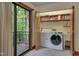 Convenient laundry room with washer, dryer, sink, storage shelves, and a door to an outdoor deck at 3622 Moonlight Dr, Chapel Hill, NC 27516
