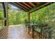 Relaxing covered patio with a table and chairs, surrounded by tranquil forest views at 3622 Moonlight Dr, Chapel Hill, NC 27516