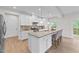 An open kitchen with white cabinets, granite counters, stainless appliances, and a counter with seating at 3700 Horton Hill Dr, New Hill, NC 27562