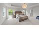 Spacious main bedroom showcasing tray ceiling, neutral decor, and ample natural light at 3700 Horton Hill Dr, New Hill, NC 27562