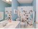 Bathroom with a blue color scheme, floral shower curtain, and a neutral-toned countertop and mirror at 401 Robert Hunt Dr, Carrboro, NC 27510
