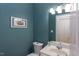 Stylish half bathroom featuring blue walls, a white vanity, and framed artwork at 401 Robert Hunt Dr, Carrboro, NC 27510
