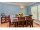 Charming dining room with wood table and chairs, wainscoting, a pendant light fixture, and large windows at 401 Robert Hunt Dr, Carrboro, NC 27510