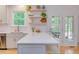 Bright, updated kitchen featuring a quartz island with white cabinets, open shelving, and stainless appliances at 401 Robert Hunt Dr, Carrboro, NC 27510
