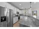 Bright kitchen featuring stainless appliances, granite countertops, and white cabinetry at 412 W Stalllings St, Clayton, NC 27520
