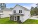 Rear view of the home with a screened-in porch and a lush green yard at 412 W Stalllings St, Clayton, NC 27520